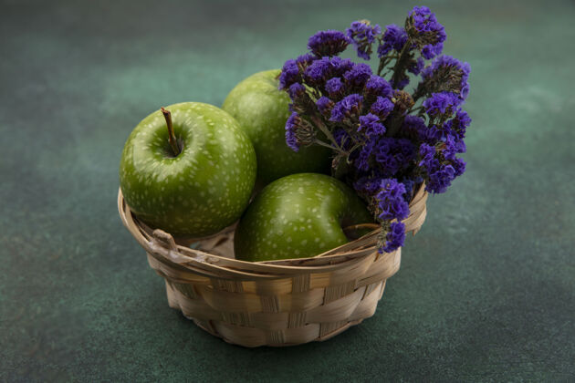 食物前视图绿色背景上有紫色花朵的篮子里的绿色苹果篮子花水果