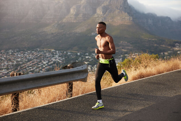 运动健活方式横幅全景图快速非洲裔美国男子有氧跑步 在户外摆姿势 穿紧身裤和运动鞋 享受速度 在落基山脉新鲜空气在户外锻炼思想动机运动员