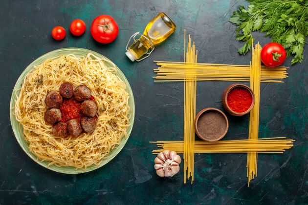 膳食俯视美味的意大利面食与肉丸和番茄酱在深蓝色背景面团面食菜晚餐意大利生的肉肉丸