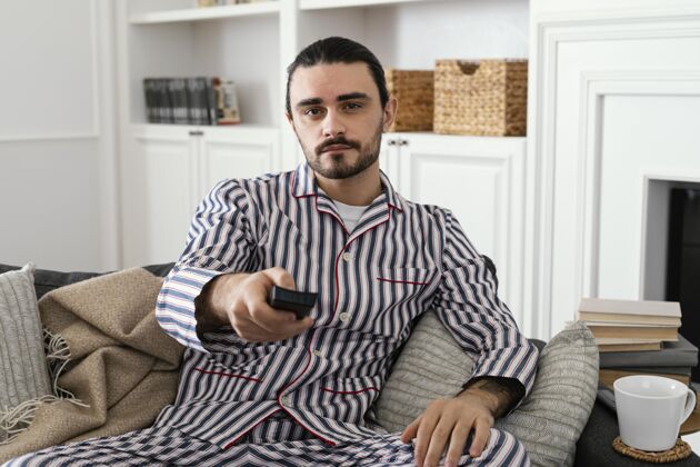 活动穿睡衣的男人在室内消磨时间成人早晨休闲时间