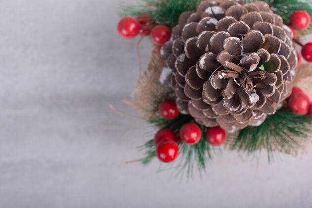 雪花白色桌子上装饰着冬青浆果和雪花的松果浆果装饰品冬天
