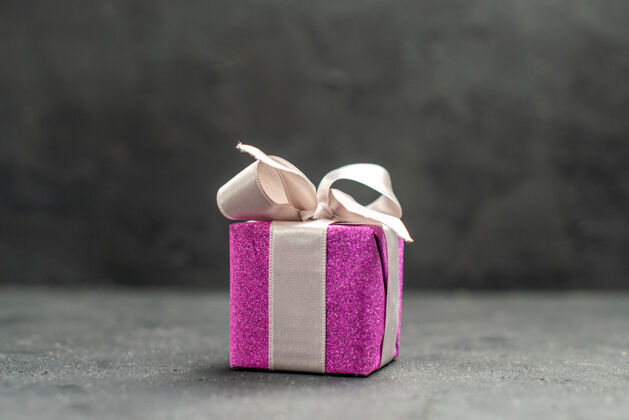 上衣顶视图粉红色礼品盒与白色丝带上黑暗孤立的表面自由空间粉色礼品盒购物景观