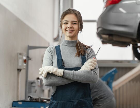 强壮在汽车服务公司工作的女人的画像工程师专业工人