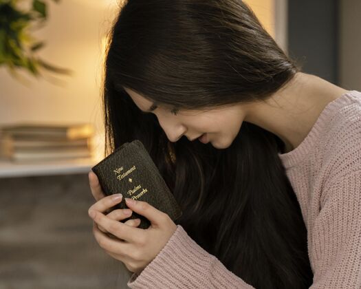 圣经妇女手持圣经祈祷的侧视图信仰信条女人