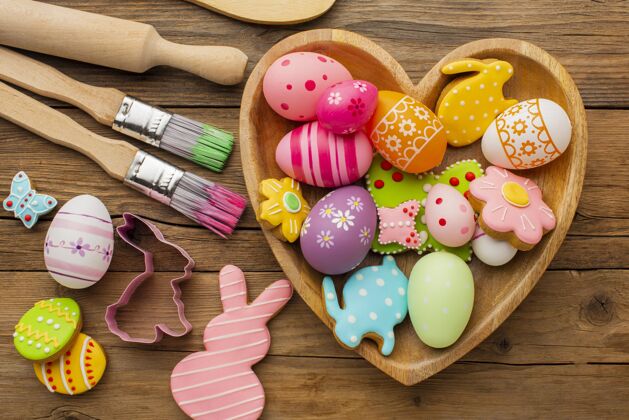 画笔顶视图彩色复活节彩蛋在心形板与厨房用具多彩节日颜色