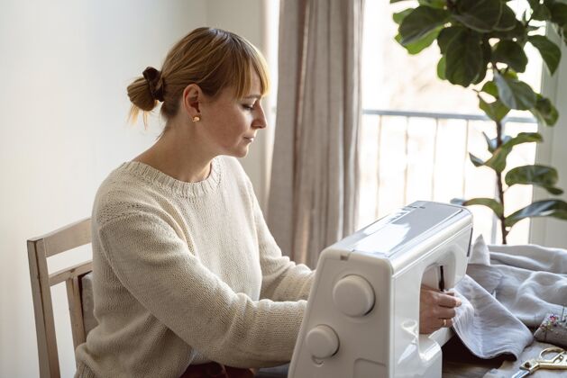 裁缝侧视图裁缝妇女使用缝纫机手工制作缝纫爱好