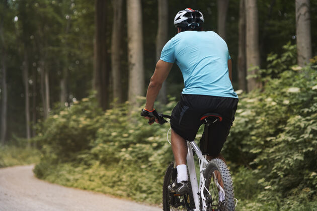 背森林里骑自行车的人一个人在移动骑自行车的