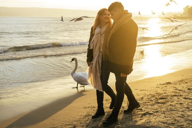 男人冬天在沙滩上散步的情侣消遣户外休闲