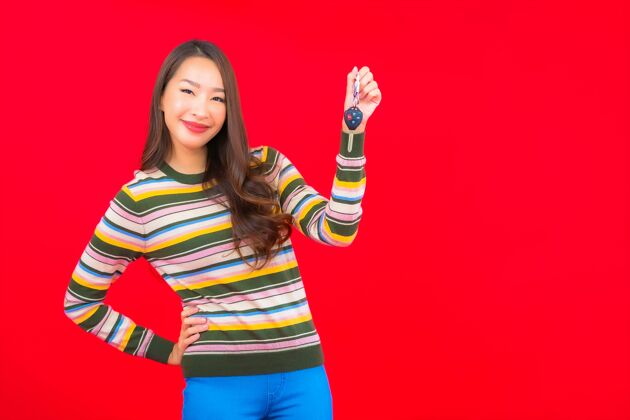 出租在红色的隔离墙上画一幅美丽的亚洲年轻女子拿着车钥匙青少年汽车微笑