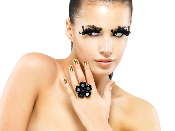 化妆美丽女人的特写肖像 黑色假睫毛 金色指甲戒指宝石珠宝