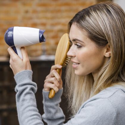 理发师女人在家吹干头发的侧视图修女发型师理发