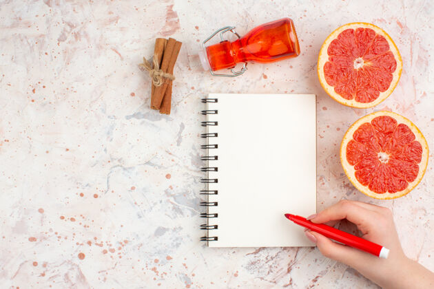 学校俯视图切割柚子肉桂棒瓶子记事本红色标记在女性手上裸体表面与复制空间卷笔刀肉桂切柚子