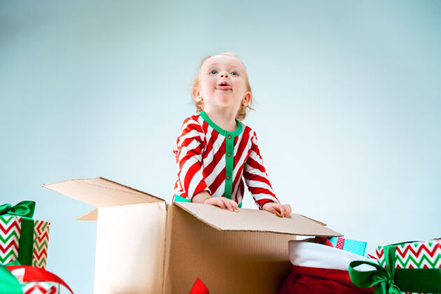 坐着可爱的女婴1岁坐在盒子里过圣诞节惊讶情感布