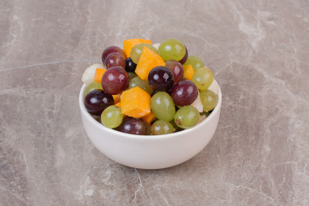 食用一碗混合水果放在大理石表面有机甜味南瓜