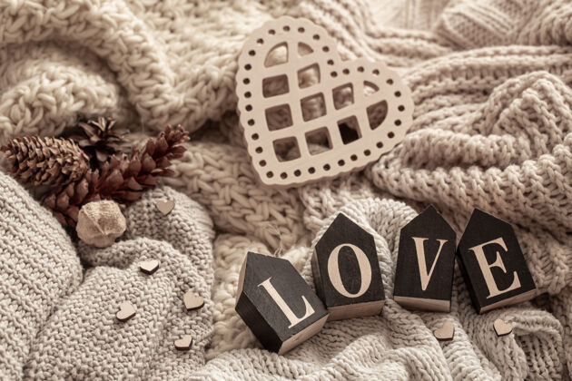 文字在舒适的针织物的背景上 木制字母组成了“爱”这个词爱情针织面料