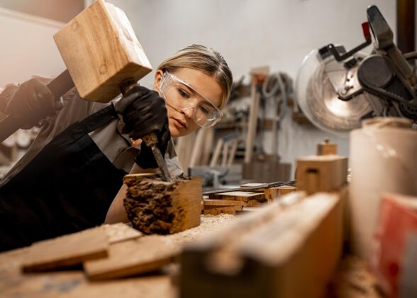 女性工作室里的女木匠拿着木雕工具工作工人妇女