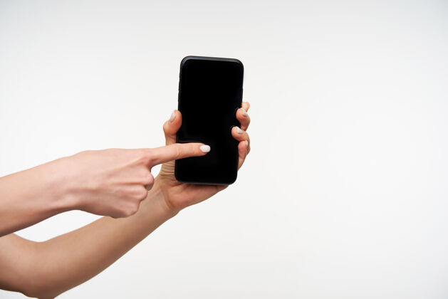 语言现代黑色手机的特写镜头被举起的女人的手拿着 用食指在屏幕上滑动 而站在白色的美甲指甲女性