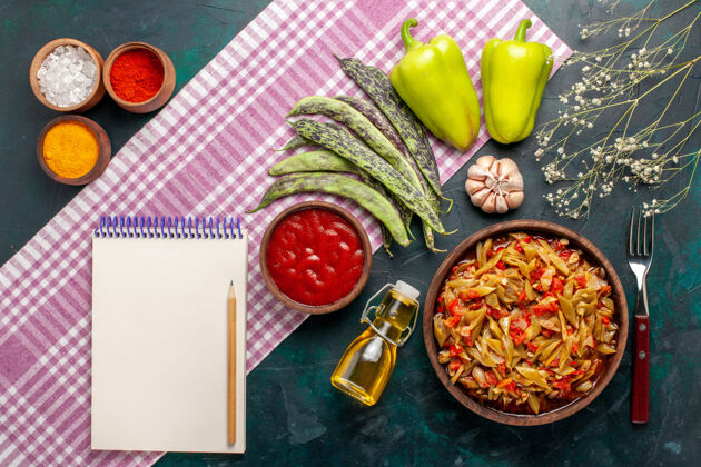 切片俯瞰蓝桌上的蔬菜切片美味豆子餐 配橄榄油和调味品盘子橄榄蔬菜