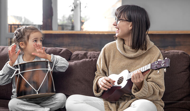 创意妈妈和女儿在家里玩上乐器课孩子的成长和家庭价值观孩子的友谊和家庭观念年轻一起四弦琴