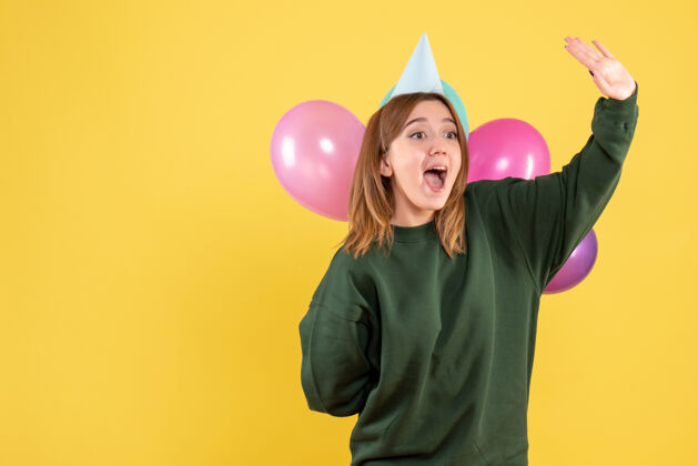 气球正面图年轻女性藏着五颜六色的气球年年轻的女性年轻