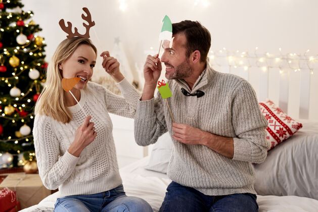 情侣戴着圣诞面具的顽皮情侣成人室内脸