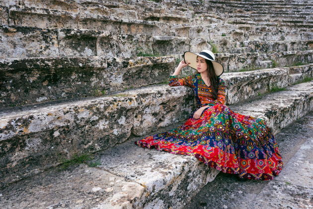 女性一个穿着波西米亚服装的女人坐在土耳其帕穆卡莱希拉波里斯古城的剧院里剧院文化自然