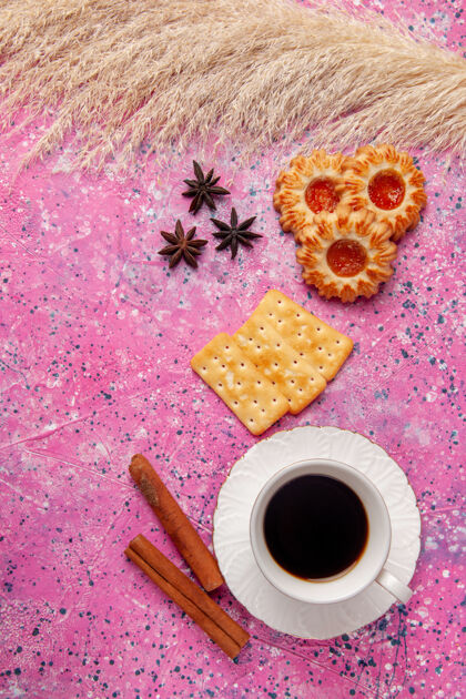 铅笔顶视图一杯茶 放在粉红色的饼干和饼干桌上酥脆的饼干甜甜的糖视图卷笔刀饼干