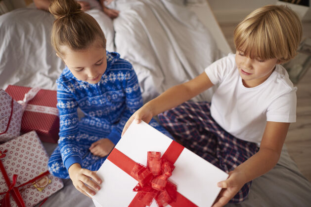 礼物孩子们在床上打开圣诞礼物家装饰品家里室内