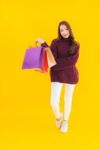 泰语用五颜六色的购物袋描绘美丽的亚洲年轻女子支付手机亚洲