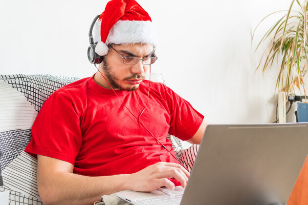 工作年轻的白种人在圣诞节期间在家工作成功坐互联网