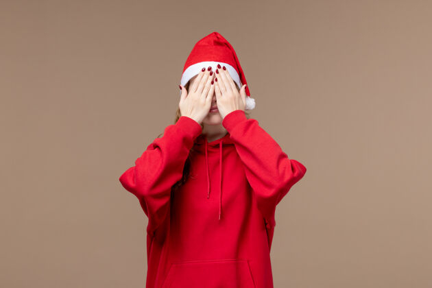 衣服正面图圣诞节女孩覆盖她的脸上棕色背景模型假日圣诞节肖像风衣风衣