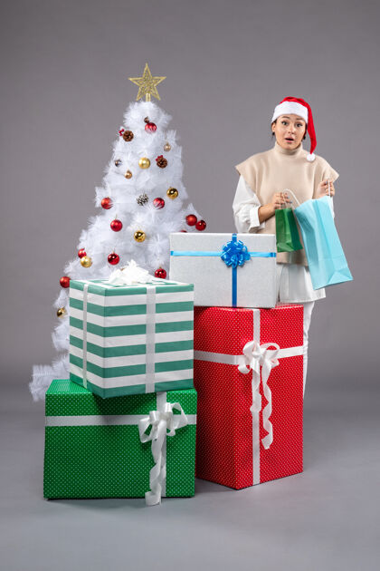 购物点亮圣诞礼物的年轻女性圣诞树礼物服装