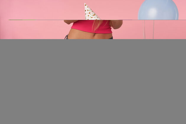 金发年轻的金发美女 穿着粉色上衣 头戴节日锥形帽 站在粉色背景下 兴高采烈地摆出五颜六色的气球盒子节日20多岁