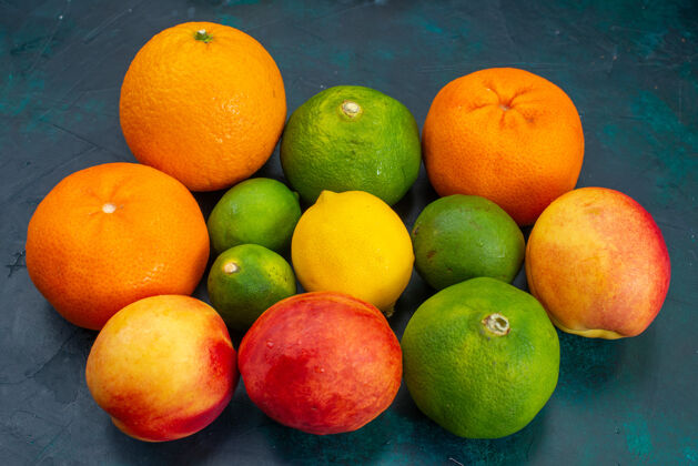 橘子前视橘子和桃子新鲜醇厚的深蓝色桌上水果维生素异国柑橘醇香柠檬深蓝色