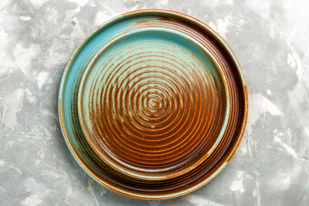 运动浅灰色表面上的圆形棕色空平底锅俯视图圆形餐具厨房