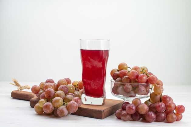 玻璃杯正面图白桌上的酸鲜葡萄汁水果鲜醇果汁饮料观点新鲜葡萄