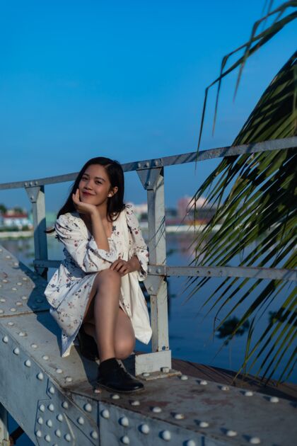 越南微笑的黑发越南女孩坐在桥上长老桥牌