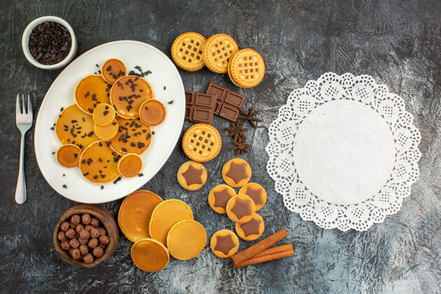 棕色不同种类的糖果和灰色地面上的一块蕾丝顶视图顶部片餐点