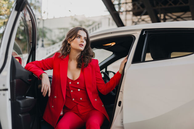 燕尾服穿着红西装的性感富商美女在白色汽车里摆姿势女人女性魅力