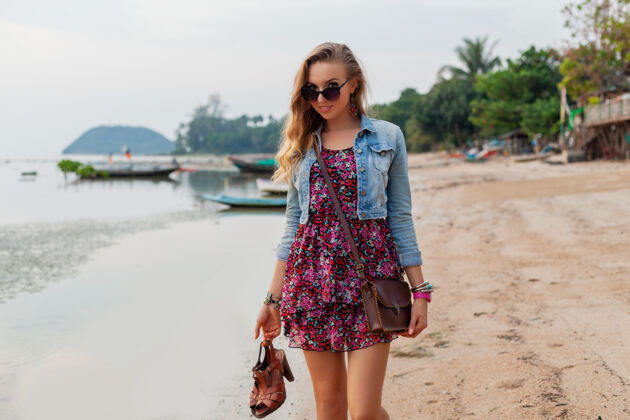 美丽时尚的女人在夏天穿着度假鞋走在沙滩上海滩乐趣感性