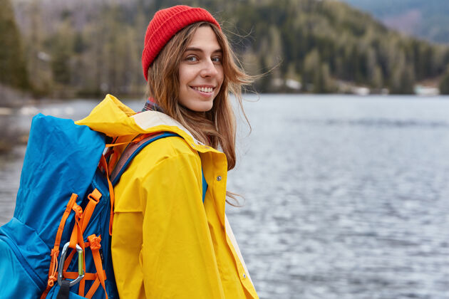 山谷美丽微笑的白人女旅行者背着背包探索风景背包
