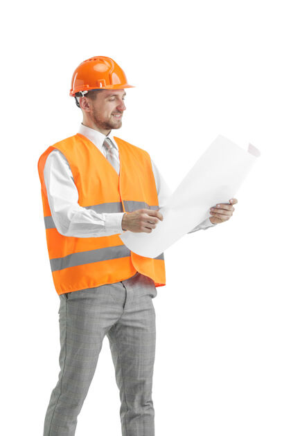 保护穿着建筑背心和橙色头盔的建筑工人站在白色的工作室里建筑设备工人