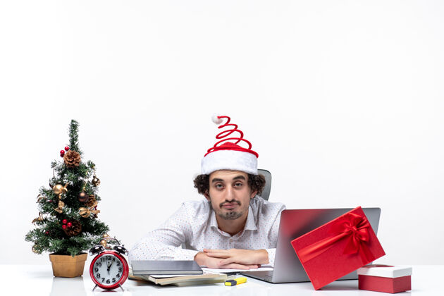 成年人新年心情与忙碌的年轻商人与有趣的圣诞老人帽子感到疲惫的一切在白色背景的办公室微笑商人圣诞老人
