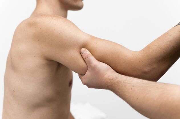 男人按摩男子手臂的理疗师侧视图物理治疗师治疗治疗学