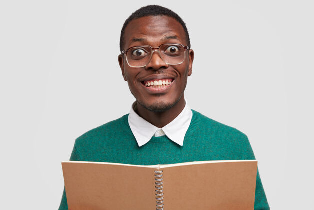 智能正男学子积极微笑 露出洁白的牙齿 拿着打开的笔记本 戴着眼镜 心情很好学习阅读学生