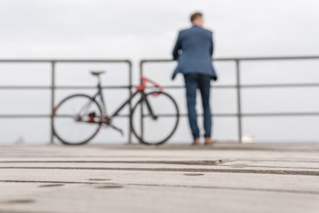 自行车穿着服装的男人站在自行车旁边骑自行车的骑骑自行车的