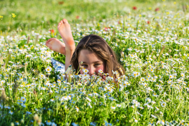多彩可爱的小女孩躺在盛开的草地上享受明亮花