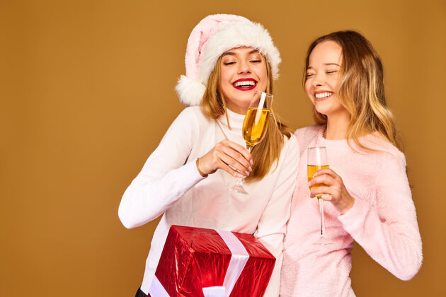 玩具带着大礼盒的模特戴着酒杯喝香槟庆祝新年白种人帽子女朋友