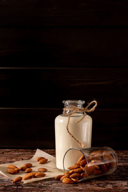 健康饮食杏仁牛奶装在一个瓶子里 在深色复古木背景上 有复制空间健康习惯健康饮料选择性关注