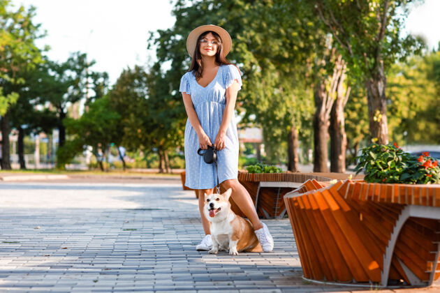 成人女人带着可爱的科吉狗在户外散步有趣纯种业主